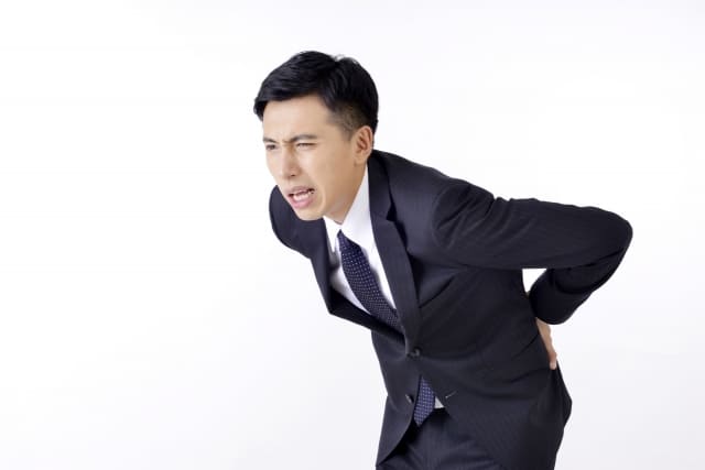 腰を痛がる男性